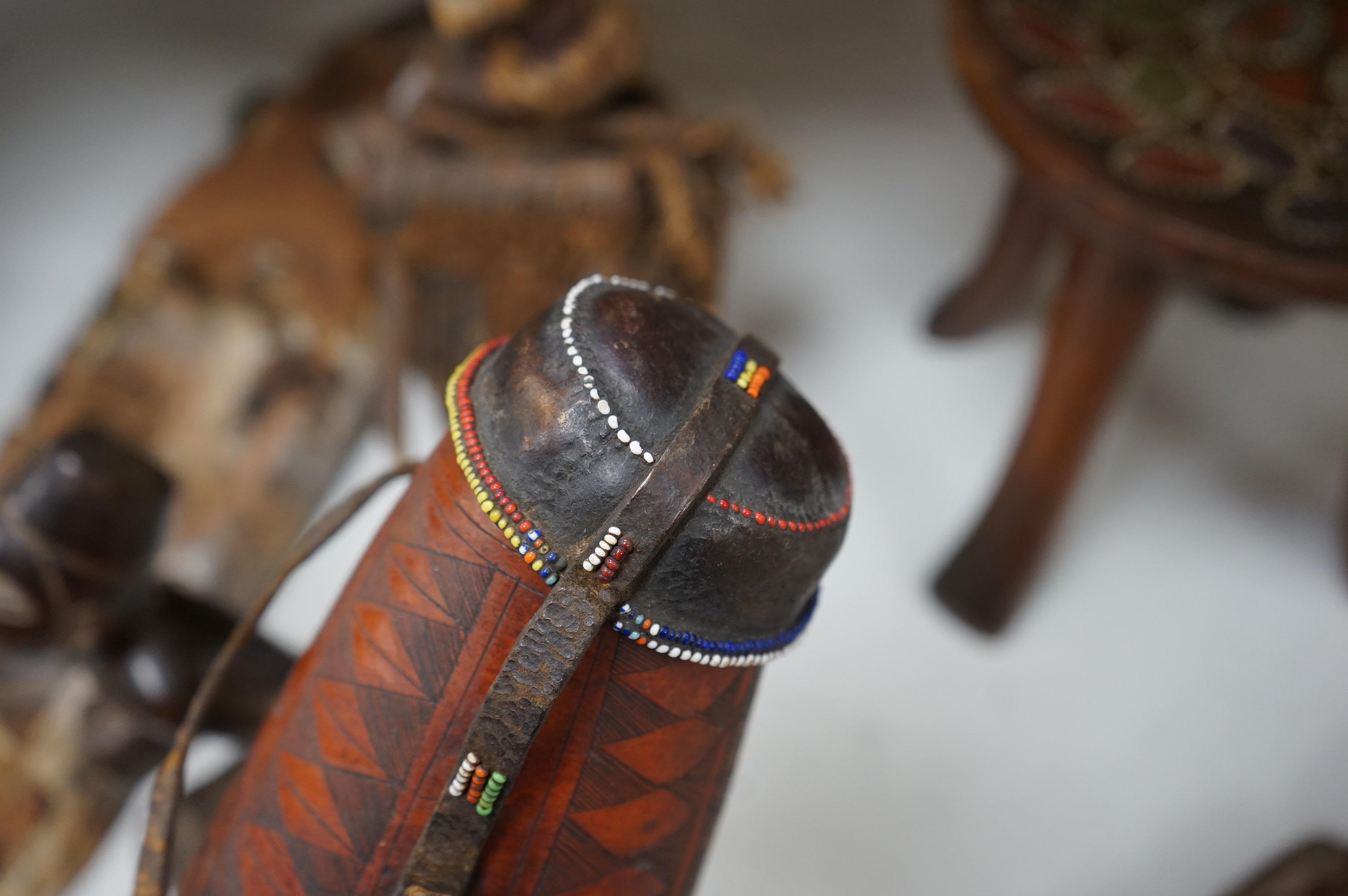 A group of African tribal artefacts, including a stool, a large painted carved mask, a carved gourd container and three carved figures, mask 76cm high. Condition- fair to good